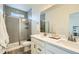 Bathroom with double sinks, vanity, and tiled glass shower at 12345 Festival Ln, Thornton, CO 80241