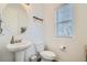 Powder room with a pedestal sink, decorative mirror, and a window with blinds at 12345 Festival Ln, Thornton, CO 80241