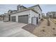 Exterior angle of home with two car garage and gravel landscaping at 12345 Festival Ln, Thornton, CO 80241