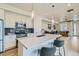 Modern kitchen with a large island, stainless steel appliances, and a view of the living room at 12345 Festival Ln, Thornton, CO 80241