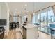 Open-concept kitchen with stainless appliances, island, and adjacent dining and living areas at 12345 Festival Ln, Thornton, CO 80241