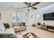 Comfortable living room with a cozy sofa, ceiling fan, and plenty of natural light at 12345 Festival Ln, Thornton, CO 80241