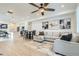 Open-concept living room with modern furnishings and bright white walls that flow into the dining area at 12345 Festival Ln, Thornton, CO 80241