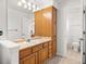 Bathroom featuring an oak vanity with a neutral countertop and a large mirror at 10631 Clarke Farms Dr, Parker, CO 80134