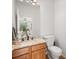 Half bathroom featuring a wood vanity with granite countertop and a modern toilet at 10631 Clarke Farms Dr, Parker, CO 80134
