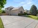 A well-maintained, two-story home with a large concrete driveway and a well-manicured lawn on a sunny day at 10631 Clarke Farms Dr, Parker, CO 80134