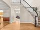 Elegant foyer showcasing a staircase with decorative balusters and hardwood floors leading to a spacious living room at 10631 Clarke Farms Dr, Parker, CO 80134