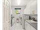 Bright laundry room features a dog door, washer, dryer, ample cabinets, and white tile flooring at 10631 Clarke Farms Dr, Parker, CO 80134
