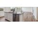 Kitchen island featuring a stainless steel dishwasher, gray countertop, and views of the living room at 27574 E Byers Ave, Aurora, CO 80018
