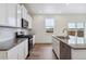Well-equipped kitchen boasts white cabinets, stainless steel appliances, subway tile backsplash, and center island at 27574 E Byers Ave, Aurora, CO 80018