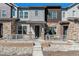 Inviting townhome with stone facade, covered porch, and landscaped front yard at 2036 S Vance Way, Lakewood, CO 80227