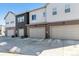 View of townhome garages, showing the concrete driveway and individual garage doors at 2036 S Vance Way, Lakewood, CO 80227