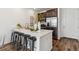 Kitchen area features stainless steel appliances, quartz countertops, island with barstools, and wood-look floors at 2036 S Vance Way, Lakewood, CO 80227