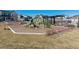 Community playground with green and beige climbing equipment on a mulch surface surrounded by landscaping at 2036 S Vance Way, Lakewood, CO 80227