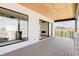 Covered deck showcasing modern railings, wood ceiling, with a view of the home's living area through sliding glass doors at 11468 Alla Breve Cir, Lone Tree, CO 80134