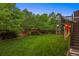 Expansive backyard with a lush lawn, mature trees, and play structure at 9810 Townsville Cir, Highlands Ranch, CO 80130