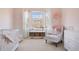 Cozy bedroom features a window, a crib and plush accent chair and dresser at 9810 Townsville Cir, Highlands Ranch, CO 80130