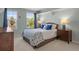 Bright bedroom features natural light, two windows, light-blue walls and comfortable queen-sized bed at 9810 Townsville Cir, Highlands Ranch, CO 80130
