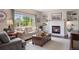 Cozy living room with a fireplace, built-in shelves, and a large window at 9810 Townsville Cir, Highlands Ranch, CO 80130