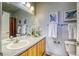 Bathroom with a wood vanity, neutral countertop, framed mirror, and toilet at 23070 York Ave, Parker, CO 80138