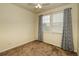 Bedroom with carpeted floors, neutral walls, and a window with patterned curtains at 23070 York Ave, Parker, CO 80138
