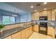 Well-lit kitchen featuring wooden cabinets, stainless steel appliances, and a breakfast bar at 23070 York Ave, Parker, CO 80138