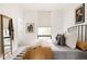 Bright bedroom with a wrought iron bed frame, modern art, and window with natural light at 3233 Tejon St # 103, Denver, CO 80211