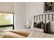 Bright bedroom with a wrought iron bed frame, modern art, and window with natural light at 3233 Tejon St # 103, Denver, CO 80211