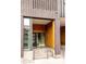 Building entrance featuring a brick facade with a wooden accent wall and a modern glass door with steps at 3233 Tejon St # 103, Denver, CO 80211
