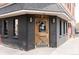 Unique corner entrance with a distinctive wooden door and black brick exterior at William & Graham at 3233 Tejon St # 103, Denver, CO 80211