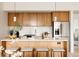 Modern kitchen with wooden cabinets, stainless steel appliances, quartz countertops, and an island with bar seating at 3233 Tejon St # 103, Denver, CO 80211