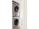 Modern, stacked washer and dryer maximizing space in a compact laundry area, next to a hallway at 3233 Tejon St # 103, Denver, CO 80211