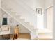 Hallway with a staircase featuring light wood steps and white rails, and a sitting chair at 3233 Tejon St # 103, Denver, CO 80211