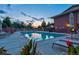 Community pool with lounge chairs, tables and umbrellas surrounded by brick wall and landscaping at 2800 S University Blvd # 170, Denver, CO 80210