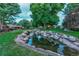 Serene backyard with a rock-lined pond and lush greenery with mature trees at 2800 S University Blvd # 170, Denver, CO 80210