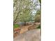 Landscaped backyard with mature trees, blooming shrubs, and paved walkway at 10824 Quail Ridge Dr, Parker, CO 80138
