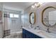 Bright bathroom featuring double sinks, modern fixtures, and a shower with tiled walls at 10824 Quail Ridge Dr, Parker, CO 80138