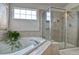 Modern bathroom featuring a large tub, glass-enclosed shower with tile surround and fixtures at 10824 Quail Ridge Dr, Parker, CO 80138
