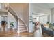 Open-concept foyer with hardwood floors, curved staircase, and views to dining and living areas at 10824 Quail Ridge Dr, Parker, CO 80138
