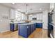 Stunning kitchen boasts blue and white cabinets, stainless steel appliances, and a center island at 10824 Quail Ridge Dr, Parker, CO 80138