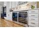 Kitchen features wine and beverage cooler, white cabinetry, and marble backsplash at 10824 Quail Ridge Dr, Parker, CO 80138