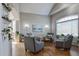 Bright living room featuring hardwood floors, accent wall lighting, and comfortable plaid armchairs at 10824 Quail Ridge Dr, Parker, CO 80138