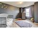 Unique bedroom with dark gray walls and natural-toned wood flooring, plus whimsical decor at 282 Vialpando St, Brighton, CO 80601