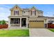 Charming two-story home featuring stone accents, a covered porch, well-kept lawn, and a two car garage at 282 Vialpando St, Brighton, CO 80601