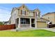 Charming two-story home featuring stone accents, a covered porch, well-kept lawn, and a two car garage at 282 Vialpando St, Brighton, CO 80601
