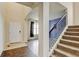 Bright foyer with hardwood and carpeted stairs, leading to a spacious living area with natural light at 282 Vialpando St, Brighton, CO 80601