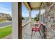 Cozy front porch with stone accents featuring outdoor seating and a view of the neighborhood at 282 Vialpando St, Brighton, CO 80601