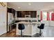 Gourmet kitchen featuring dark cabinets, stainless steel appliances, granite countertops, and an eat-in island at 282 Vialpando St, Brighton, CO 80601