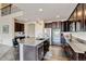 Gourmet kitchen featuring dark cabinets, stainless steel appliances, granite countertops, and an eat-in island at 282 Vialpando St, Brighton, CO 80601