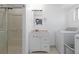 Bright bathroom and laundry featuring a shower, single vanity, window, and a washer and dryer at 7286 Wolff St, Westminster, CO 80030